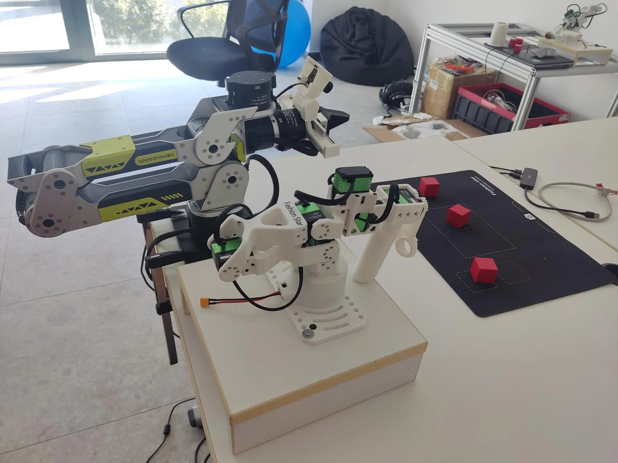 Robot arms on the workbench during a pick-and-place teaching session